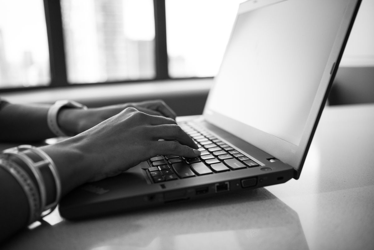 Mãos digitando em um notebook — atendimento notarial
